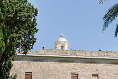 Low angle view of building and trees against sky