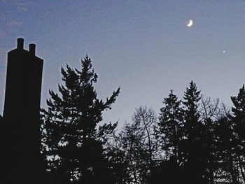 Low angle view of silhouette trees against sky