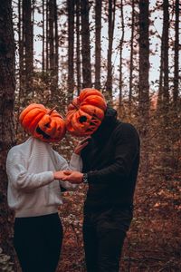 Full length of a man standing in forest whit his love in halloween