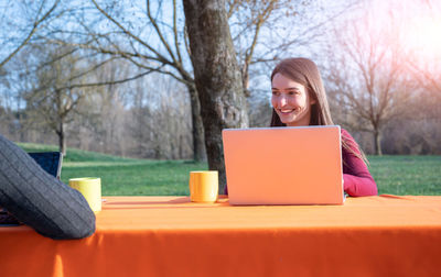 Young freelancer with laptop sitting at table