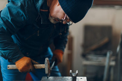 Midsection of man working in workshop