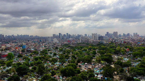 Manila north cemetery on the background of skyscrapers and modern buildings, aerial drone. 