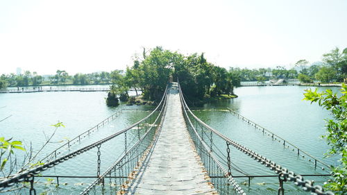 Footbridge over river against clear sky