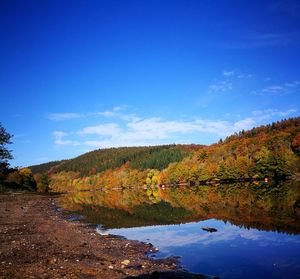 Scenic view of lake against blue sky during autumn