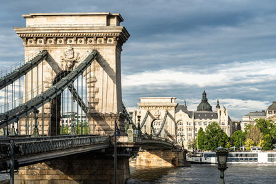 View of bridge over city against cloudy sky