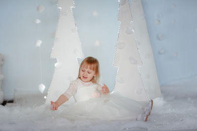 Portrait of young woman sitting on snow