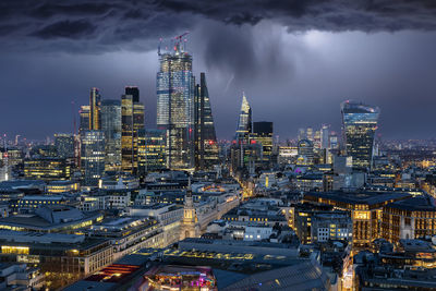 Illuminated modern buildings against sky at night