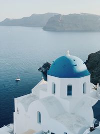 White church by sea against sky