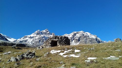 Scenic view of snowcapped mountains against clear blue sky