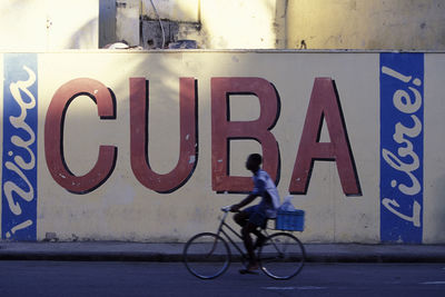 Side view of man riding bicycle sign