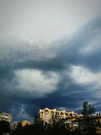 Low angle view of buildings against cloudy sky