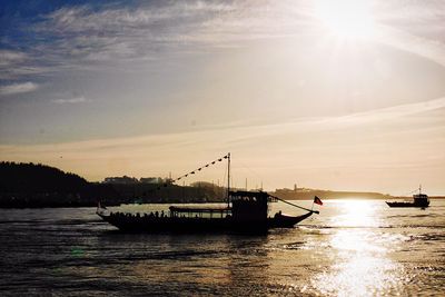 Silhouette ship in sea against sky during sunset