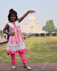 Optical illusion of smiling girl holding taj mahal