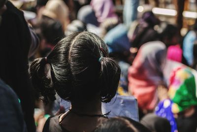 Rear view of girl standing by crowd during protest