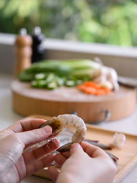 Cropped hand of person preparing food on table