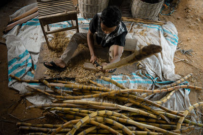 High angle view of man cutting sugarcane
