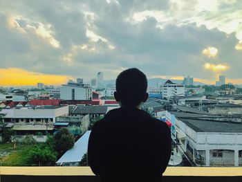 Rear view of a man overlooking cityscape