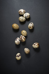 Quail eggs on a black table.