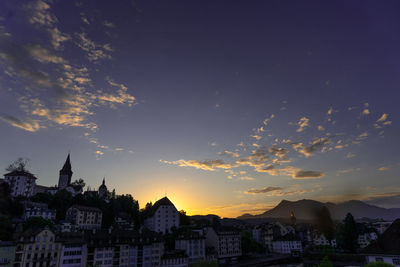 Buildings in town against sky during sunset