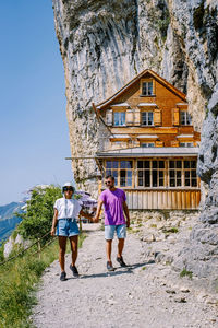 Rear view of people standing against building