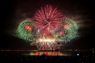 Firework display over river at night