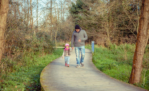 People walking on footpath amidst trees