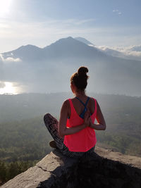 Woman doing yoga against mountains