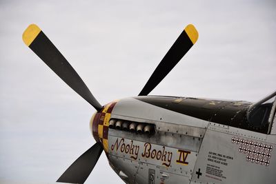 Close-up of airplane flying against sky