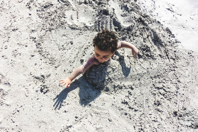 High angle view of boy in sand at beach