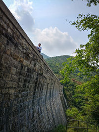 Man on tree against sky
