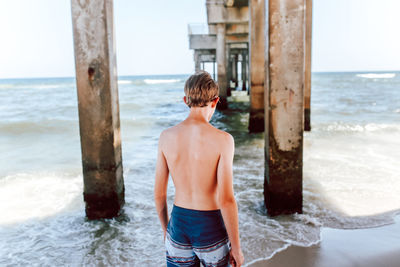 Man standing at beach against sky