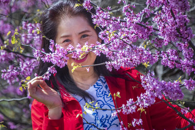 Portrait of woman against purple flowering plants