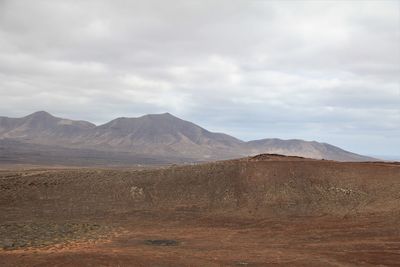 Scenic view of arid landscape mountains against sky