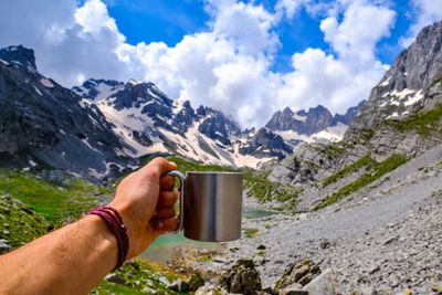 Midsection of man having food against mountains