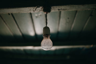 Close-up of light bulb hanging from ceiling