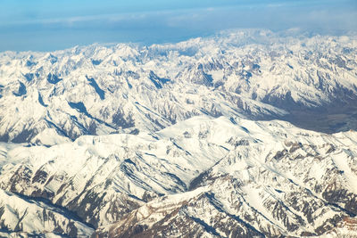 Aerial view of snowcapped mountains against sky