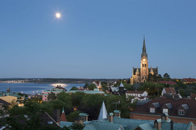 Church in city against blue sky at dusk