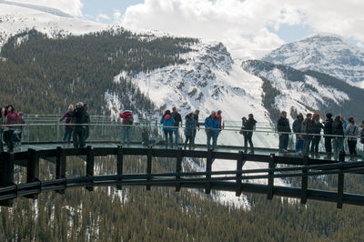 People on snowcapped mountain against sky