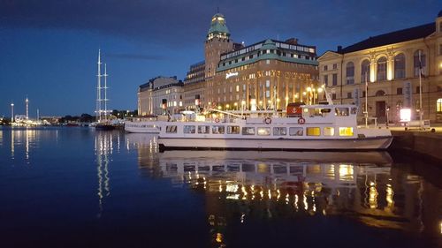 Boats moored at harbor with buildings in background