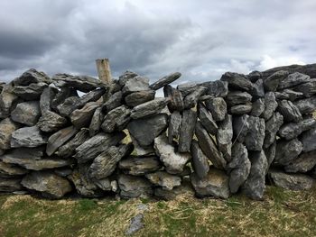 Stack of rocks against cloudy sky