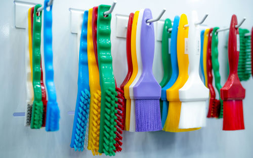 Brushes hang on shelf. color coded hygiene glazing brushes and detail brushes for food processing