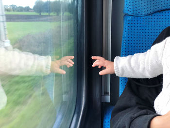 Midsection of man holding train by window