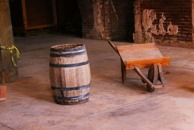 Wooden barrel and empty wheelbarrow