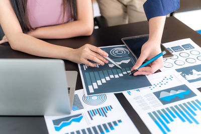 Low section of woman using laptop on table