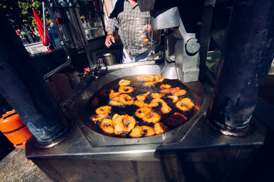 Midsection of man preparing street food at market stall