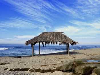 Lifeguard hut on beach against sky