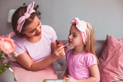 High angle view of girl holding pink while sitting at home