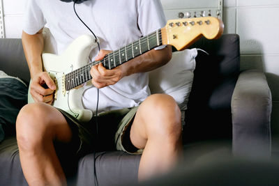 Midsection of woman playing guitar