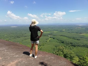 Rear view of woman standing on landscape against sky