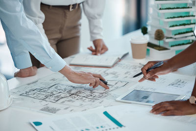 Midsection of business people working on table